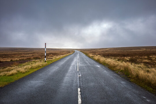 Empty road amidst field under storm clouds, County Durham, England