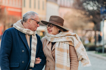 Elderly couple wearing scarfs talking to each other