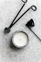 Handmade scented candles in a concrete candle holder. Wick black metal scissors and candle extinguishing bell. A modern fashionable and handy accessory for the home.