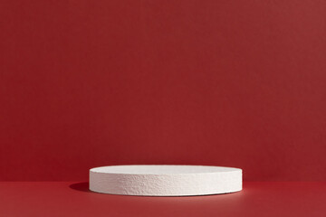 Geometric white podium on an abstract red background. Empty scene for the product presentation. Showcase, display case.