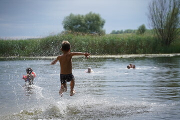 Young boys jumping into the lake.
