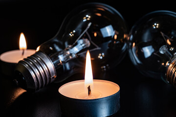 Electric lamp and candle on a dark background. Incandescent lamp and candle. No or power outage....