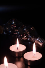 Electric lamp and candle on a dark background. Incandescent lamp and candle. No or power outage....