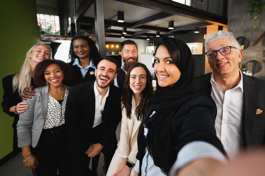 Multiracial group of businesspeople take a selfie portrait smiling.