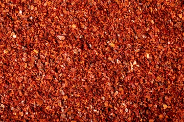 Fotobehang Red pepper flakes. Heap of crushed peppers. Top view of dried chili peppers. Close up © enezselvi