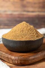 Powdered coriander spice. Coriander powder or dhaniya powder on wooden background. Dry spice concept. close up