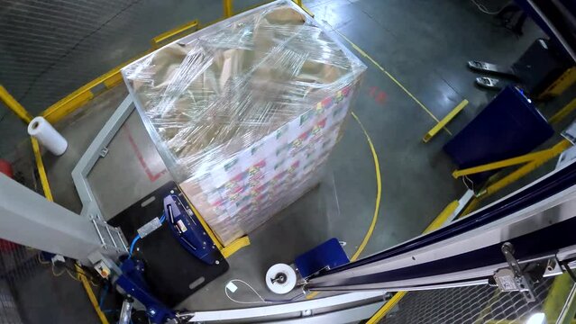 Box stretch wrapping machine. Pallet wrapping machine. Packing boxes in plastic film. Machine for wrapping boxes in a plastic film in a circle.