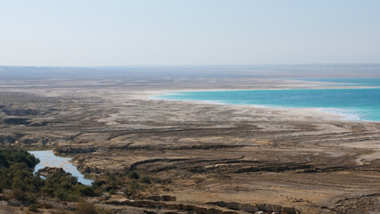 Unique patterned salt deposit shoreline of the Dead Sea with stunning turquoise saline water in Jordan Rift Valley in Jordan, Middle East