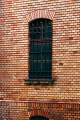 Old vintage brick wall and window with protective metal bars