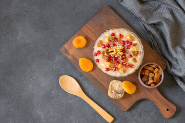 Traditional Turkish delicious mixed dessert, ashura (asure) with pomegranate seeds, walnut,...