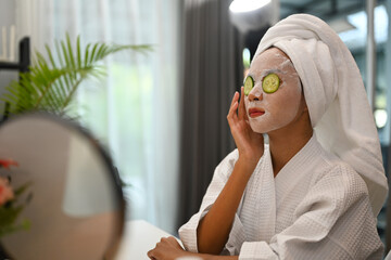 Attractive woman in bathrobe making daily beauty routine at home. Beauty treatment and self care concept