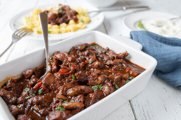 Light dinner or lunch with stewed chicken breast and vegetables in a delicious brown sauce on kitchen table background