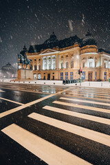 Winter night in Bucharest. Central University Library Carol I landmark building under snowfall...