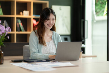 Financial analysis concept Asian woman working on documents on tablet laptop at workplace sitting at desk planning financial report business plan investment