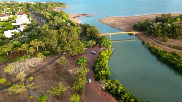 Drone aerial of blue teal retro car  down long winding road along river. Native Australian green trees skyline. ocean skyline. Sunset
thunderbird