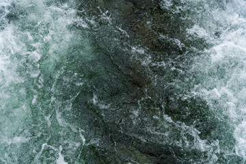 Fototapeta Close up of white water flowing down a river with melting water in Norway obraz