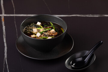 Japanese steamed miso soup with steam rising, tofu and seaweed