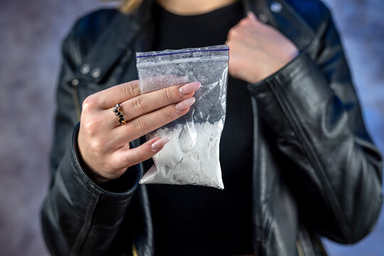 closeup of female drug dealer hold cocaine in plastic packet for sale