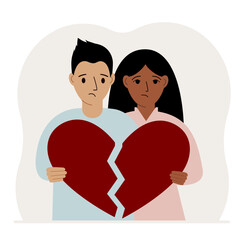 Fototapeta premium A sad man and woman are holding pieces of a broken red heart in their hands. Broken heart.