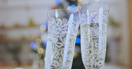 Holiday, wine glasses with champagne clink. Two people celebrate Christmas.