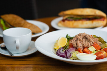 Full table of delicious and different dishes in cafe with cup of coffee in white dinnerware.