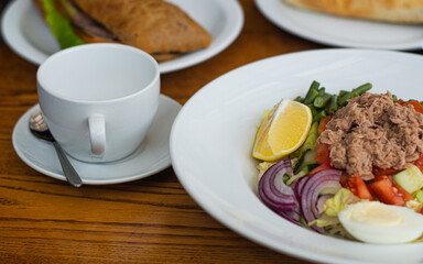 Full table of delicious and different dishes in cafe with cup of coffee in white dinnerware.