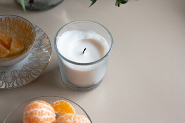 home decor. vanila candle with piled mandarins