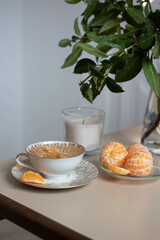 home decor. tea cup and vanila candle with piled mandarins