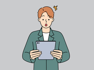 Stunned man shocked with news on tablet 