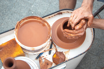 close-up of the hands of a potter busy making a clay jug on a rotating potter's wheel