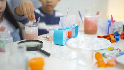 A group of Asian students kids study, learn on test tube in lab or laboratory in school, medical, chemistry. Experiment science. Education in classroom. People lifestyle