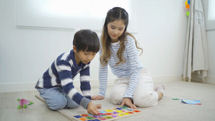 An Asian student kids and mother playing a text toy game in school. Education in classroom. Family people lifestyle.