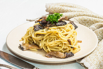 Spaghetti pasta with oyster mushrooms, creamy sauce and parsley. Healthy vegan food ready to eat