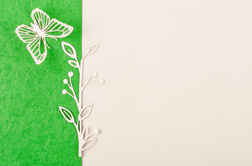 A Butterfly and flower made from carve paper or cutting on green and yellow background with empty space for your text or message.