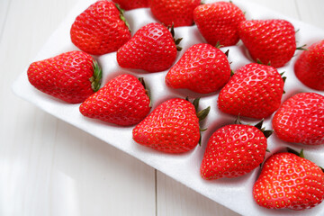 Red ripe strawberry in plastic package. Fresh strawberries. Seasonal fruits. 