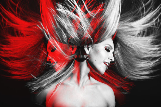 Fashion concept. Portrait of beautiful woman with flying hair in red color split effect style. Futuristic looking style. Image contains motion blur. Model with happy facial expression