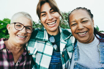 Multiracial senior women having fun together outdoor - Focus on african female face