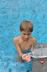 criança brincando na água da piscina 