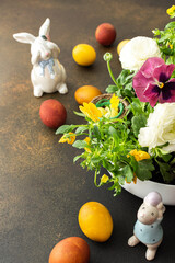 Top view of a vase with beautiful blooming flowers and Easter eggs, cute bunnies, copy space