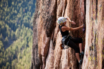 A athletic woman rock climbing near Bozeman, Montana.