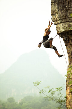 Caucasian female climber falling on a lead climb in China.