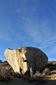 A rock climber boulders on an arete at the Buttermilks near Bishop, CA.