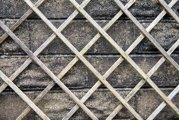 Background image of a wooden trellis on a grey brick background