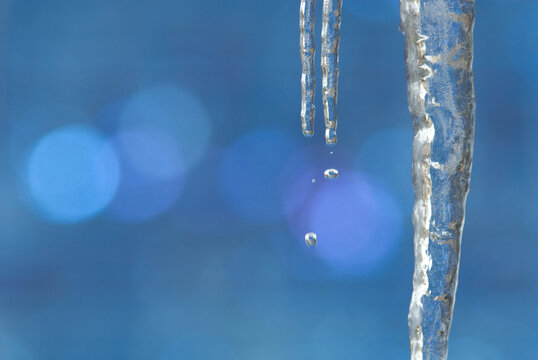 Water drop falling off front of polycrystaline structure pattern of solar panels, Durango, Colorado.  icicle in front of