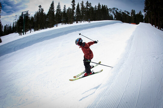 Young skier dropping into a half pipe.