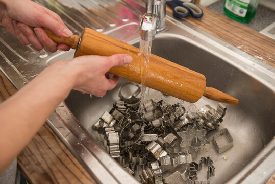 Close-up of a woman washing rolling pin and pastry cutter in kitchen sink, Munich, Bavaria, Germany