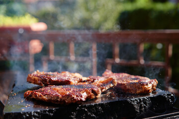 Barbecue beef burger steak. Cutlet meat placed on grill stone with fire.