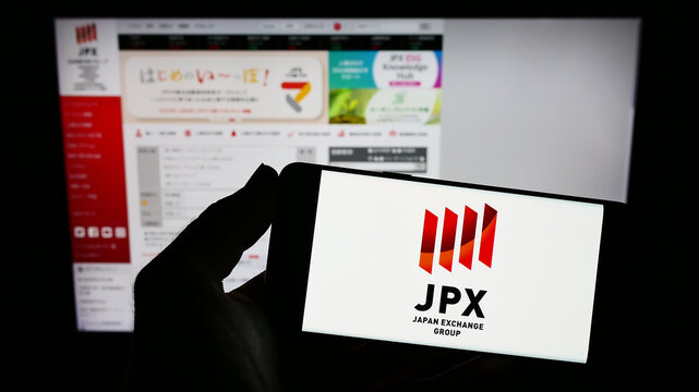 Stuttgart, Germany - 01-25-2023: Person holding smartphone with logo of company Japan Exchange Group Inc. (JPX) on screen in front of website. Focus on phone display.
