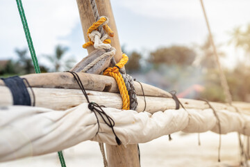 inside view of a dhow's sails and deck with bellowing sails against a blue sky
