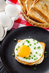 delicious fried egg sandwich on black rustic wooden background